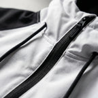 Close-up of the half-zip front with black zip pull, drawstring cords and chest zip pocket detail