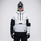 Front view of the white and black anorak styled with a bobble hat and ski goggles, hood down