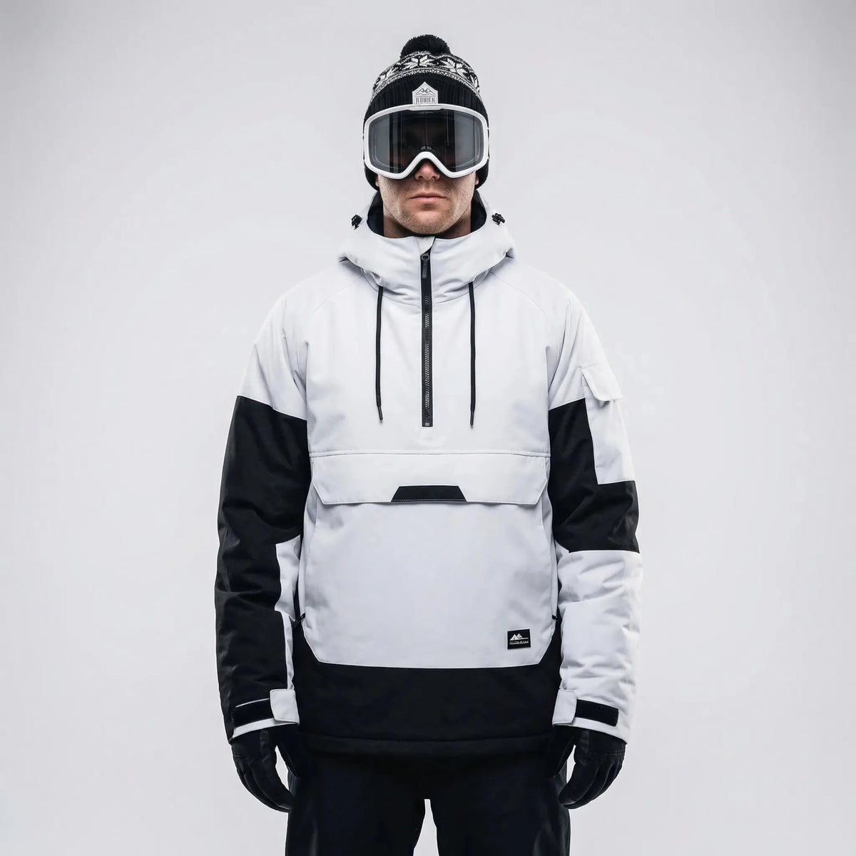 Front view of the white and black anorak styled with a bobble hat and ski goggles, hood down