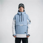 Model wearing the anorak in dusty blue and white colourblock with hood up and goggles on