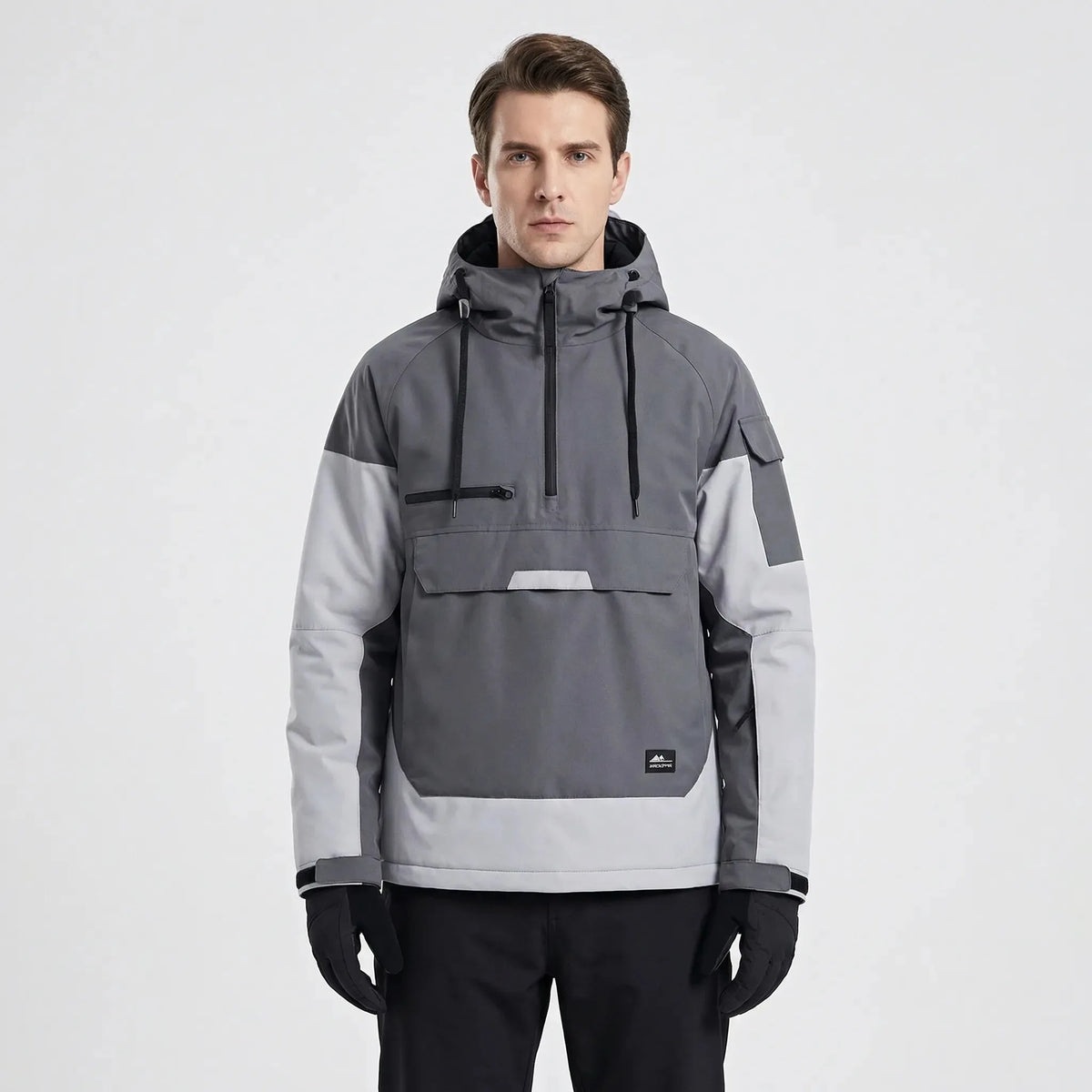 Model wearing the anorak in grey and light grey colourblock, front view showing kangaroo pocket