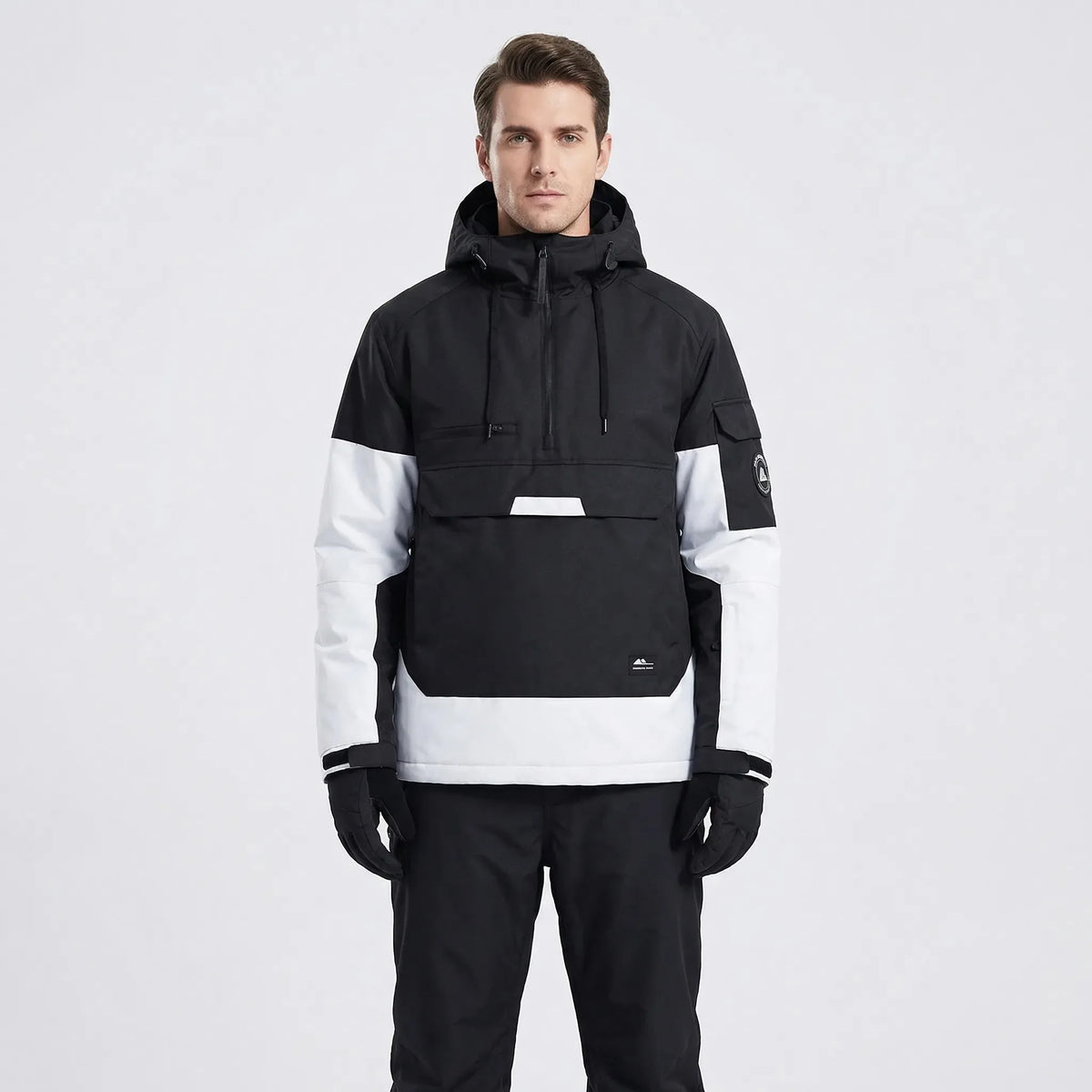Model wearing the anorak in black and white colourblock, front view with hood down