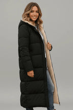 Side profile of a woman wearing the black longline puffer coat unzipped, showing the length falling past the knee