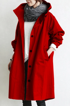 Close-up front view of a red hooded trench coat with button-through placket and stand collar