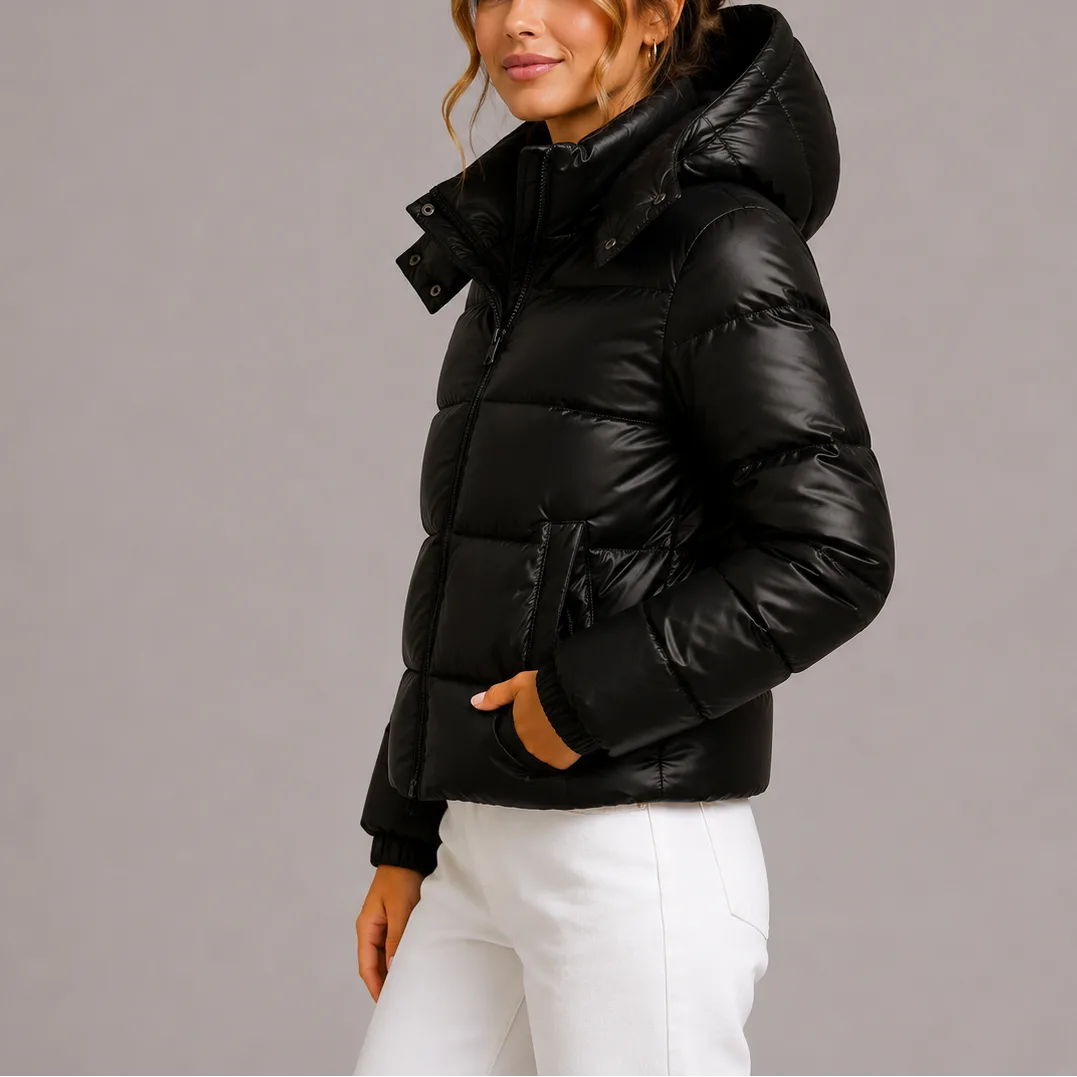 Side profile of a black glossy hooded puffer jacket with quilted horizontal channels and zip front