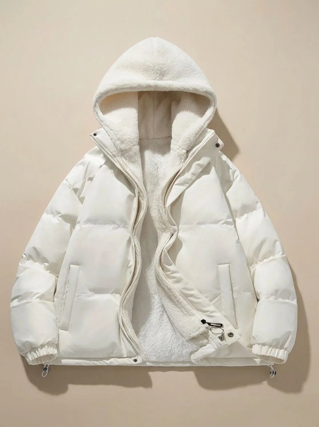 Side profile of black puffer jacket on model, highlighting quilted sleeve and hem drawcord