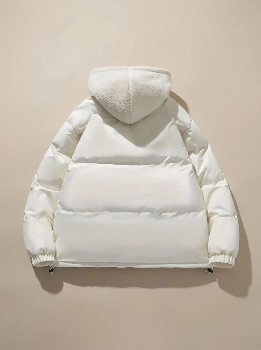 Close-up of model wearing black puffer jacket with hood up and fleece lining visible