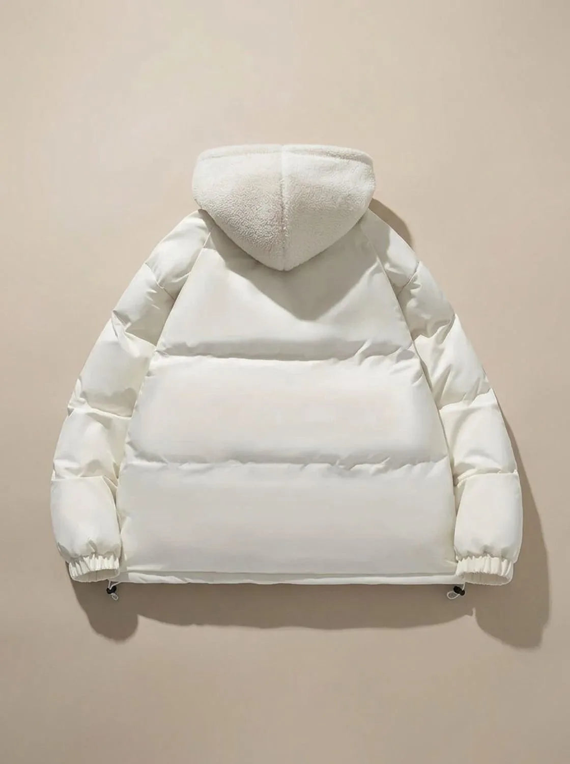 Close-up of model wearing black puffer jacket with hood up and fleece lining visible