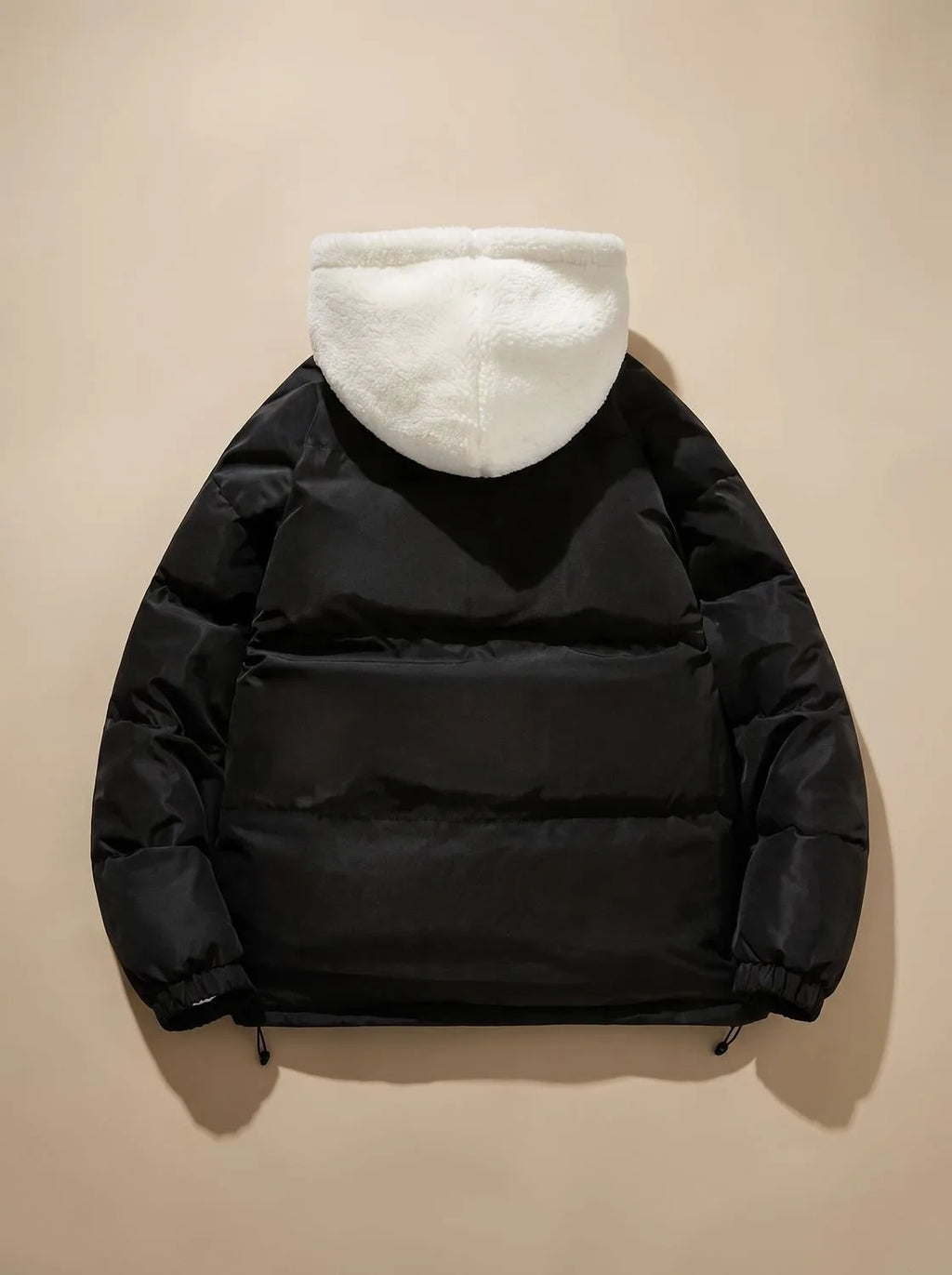 Back view of black puffer jacket showing quilted panels and cream sherpa fleece hood