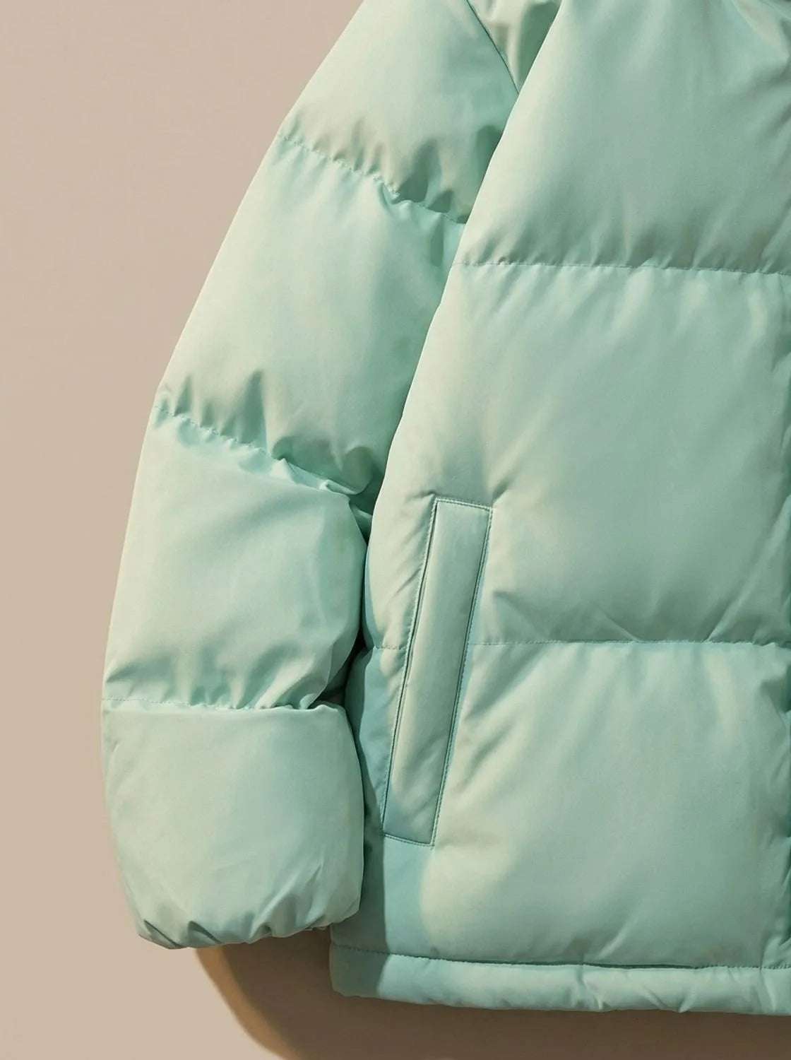 Close-up of elasticated hem drawcord toggle on puffer jacket