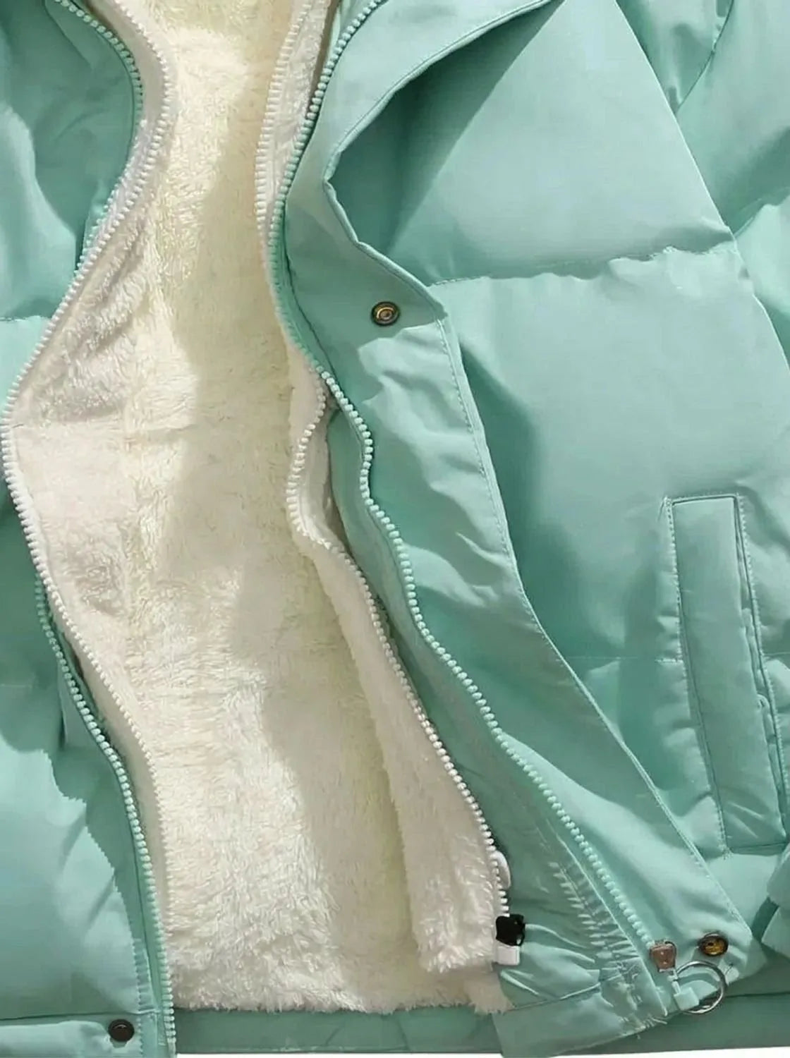 Flat lay detail showing quilted sleeve construction and side pocket stitching on puffer jacket
