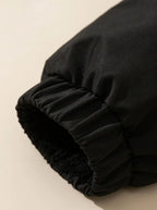 Close-up of elasticated cuff with drawcord toggle on black puffer jacket sleeve
