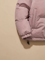 Close-up of pink puffer jacket sleeve cuff, side pocket and drawcord toggle