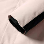 Detail shot of black jacket's front zip pockets with visible stitching and zipper tabs