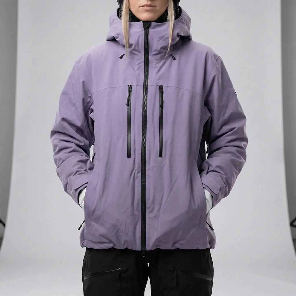 Model wearing the lilac hooded ski jacket fully zipped with hood up over a black beanie