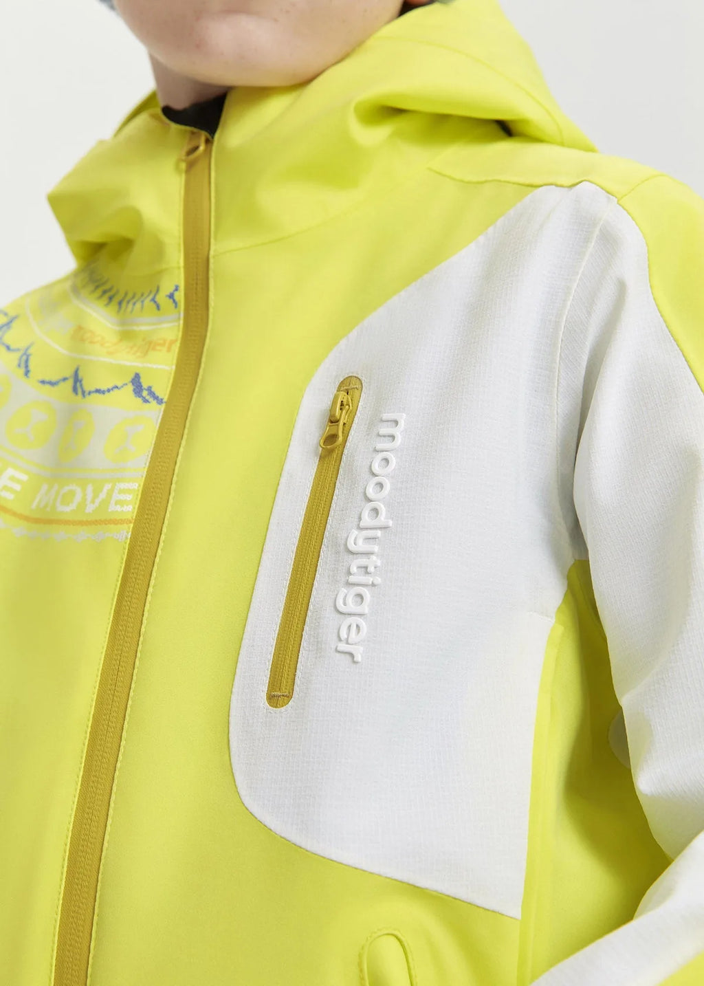Close-up of the white chest pocket with yellow zip pull and embroidered logo on the jacket