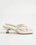 Ivory leather flip-flop style sandal with slim straps and flared spool heel, side angle