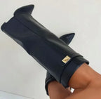 Close-up of black faux leather boot folded cuff with gold turn-lock buckle detail