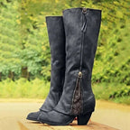 Black knee-high boots with front zip and tassel pull, showing floral lace insert above the block heel