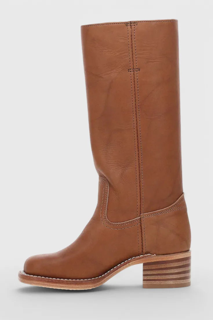 Detail shot of the wooden stacked heel and leather sole on a tan brown knee-high boot