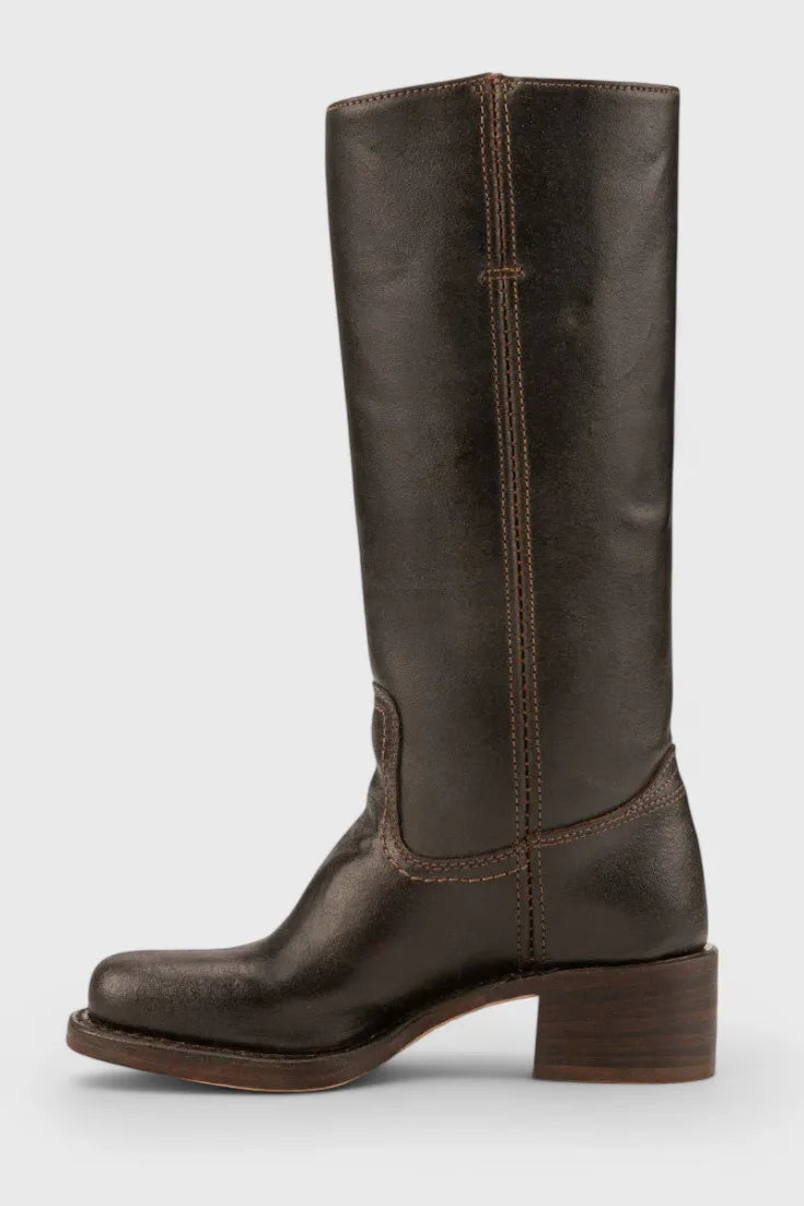 Angled view of yellow leather knee-high boots emphasising the smooth leather finish and heel shape