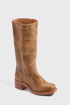 Side view of a model's legs wearing yellow knee-high leather boots with a seated pose