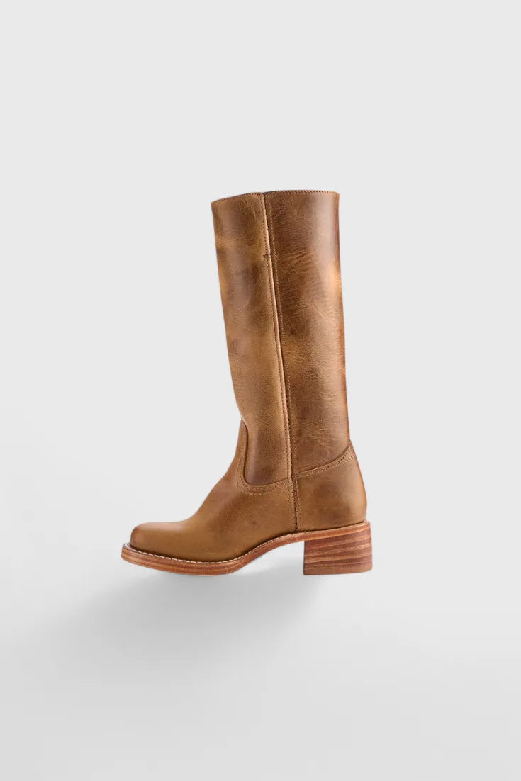 Detail view of the stacked heel construction and leather welt on a light brown knee-high boot