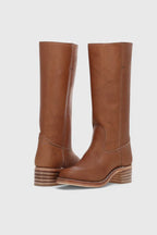Front pair view of tan brown leather knee-high boots with contrast stitching and a striped stacked heel