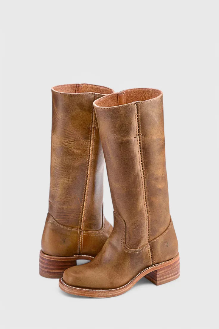 Back three-quarter view of weathered tan leather knee-high boots highlighting the natural grain and stacked heel
