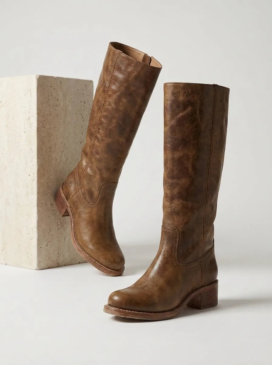 Side profile of black leather knee-high riding boots with round toe and visible shaft stitching