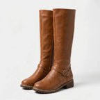 Pair of tan brown knee-high riding boots with buckle ankle strap and side zip, angled front view