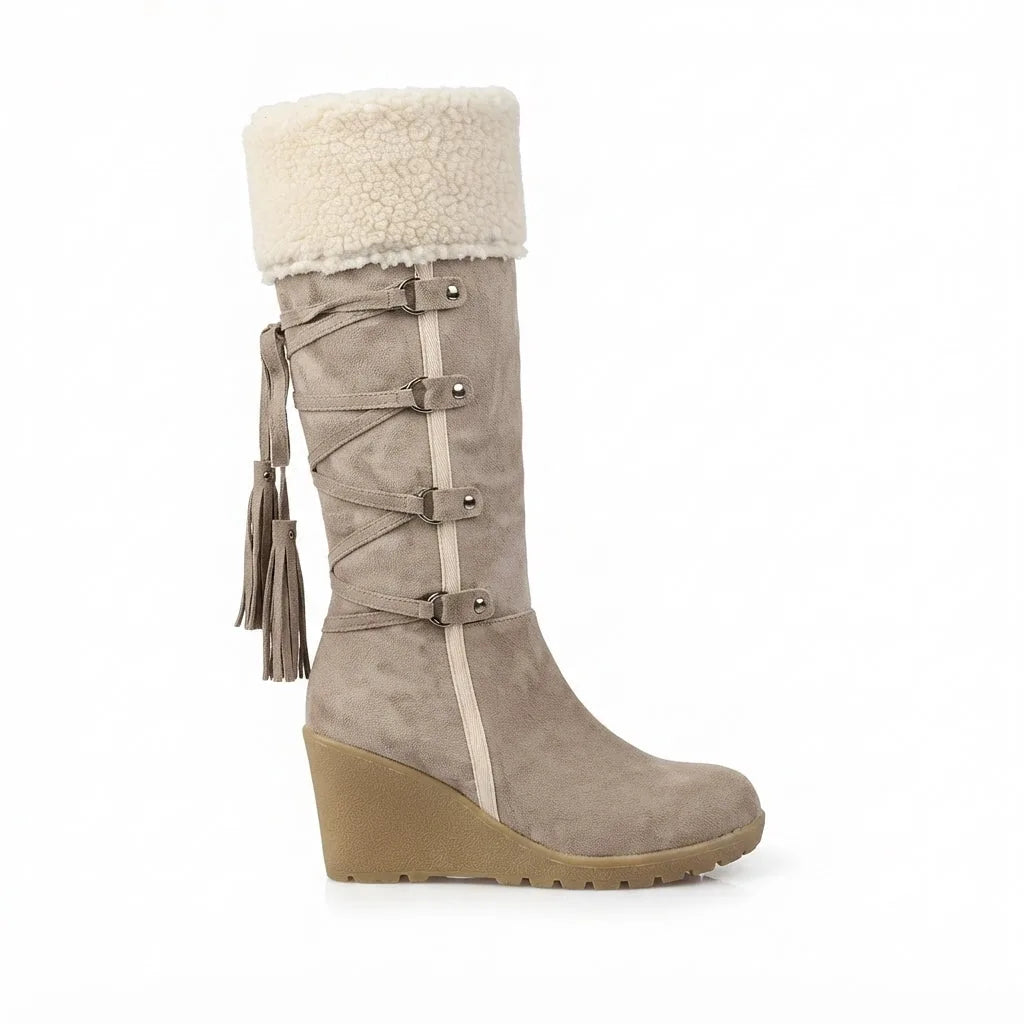 Side view of beige suede knee-high wedge boot with shearling cuff, lace detail and tassel
