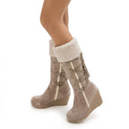 Close-up side view of model wearing beige boots with folded fleece cuff and wedge heel