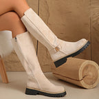 Beige suede knee-high boots with contrast stitched sole and ankle buckle, shown in profile