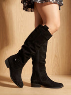 Black suede knee-high boots showing the ruched shaft, pull tab and visible side zip in full profile
