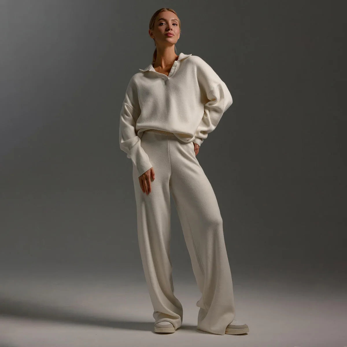 Model with hands in trouser pockets showing the relaxed fit of the blue knit two piece set