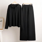 Black polo jumper and wide leg knit trousers set displayed hanging side by side on hangers