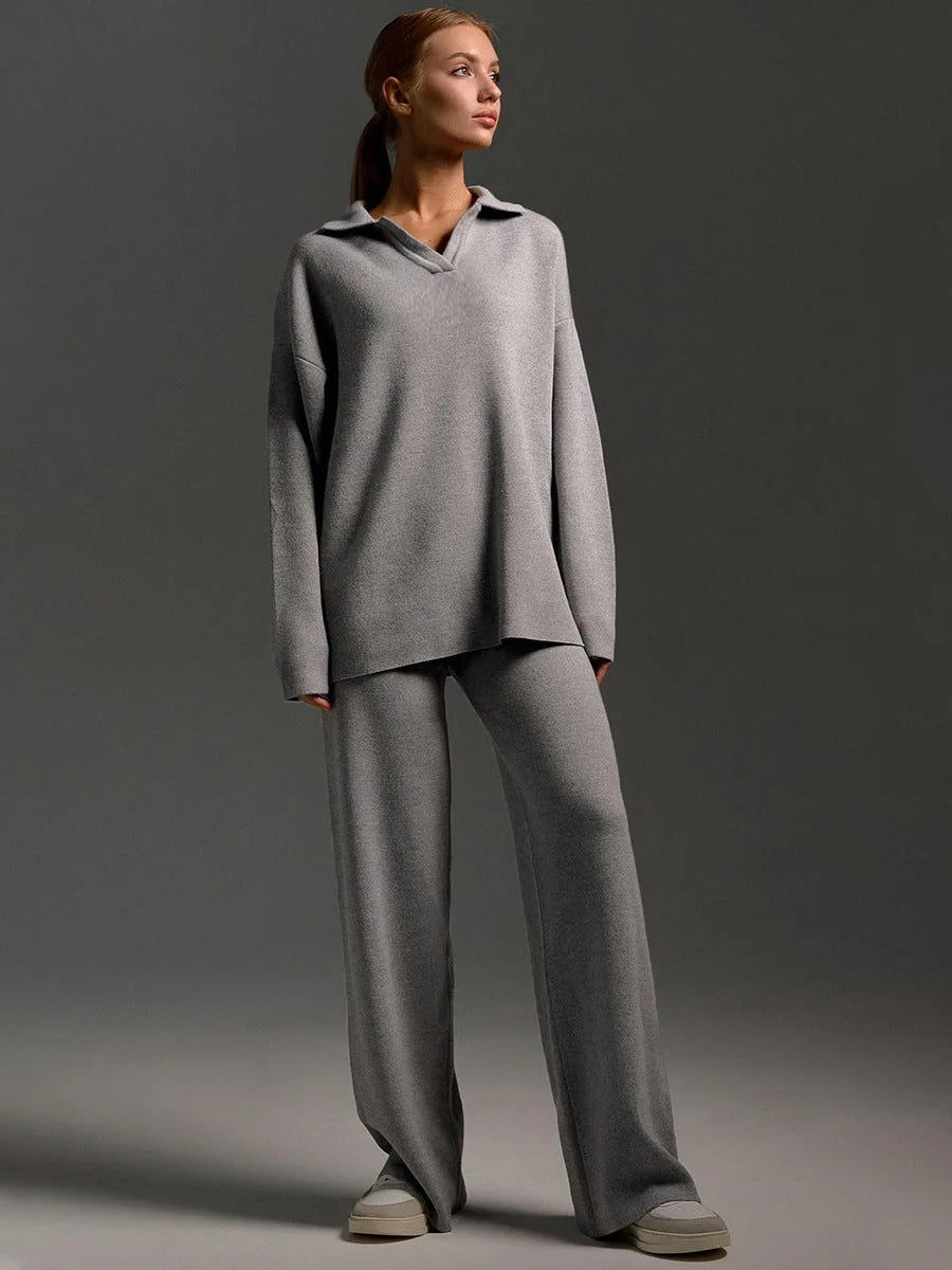 Model in grey oversized polo jumper and wide leg knit trousers, three quarter front view with trainers