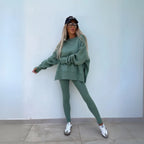 Sage green oversized sweatshirt with matching leggings worn with a black cap and white trainers