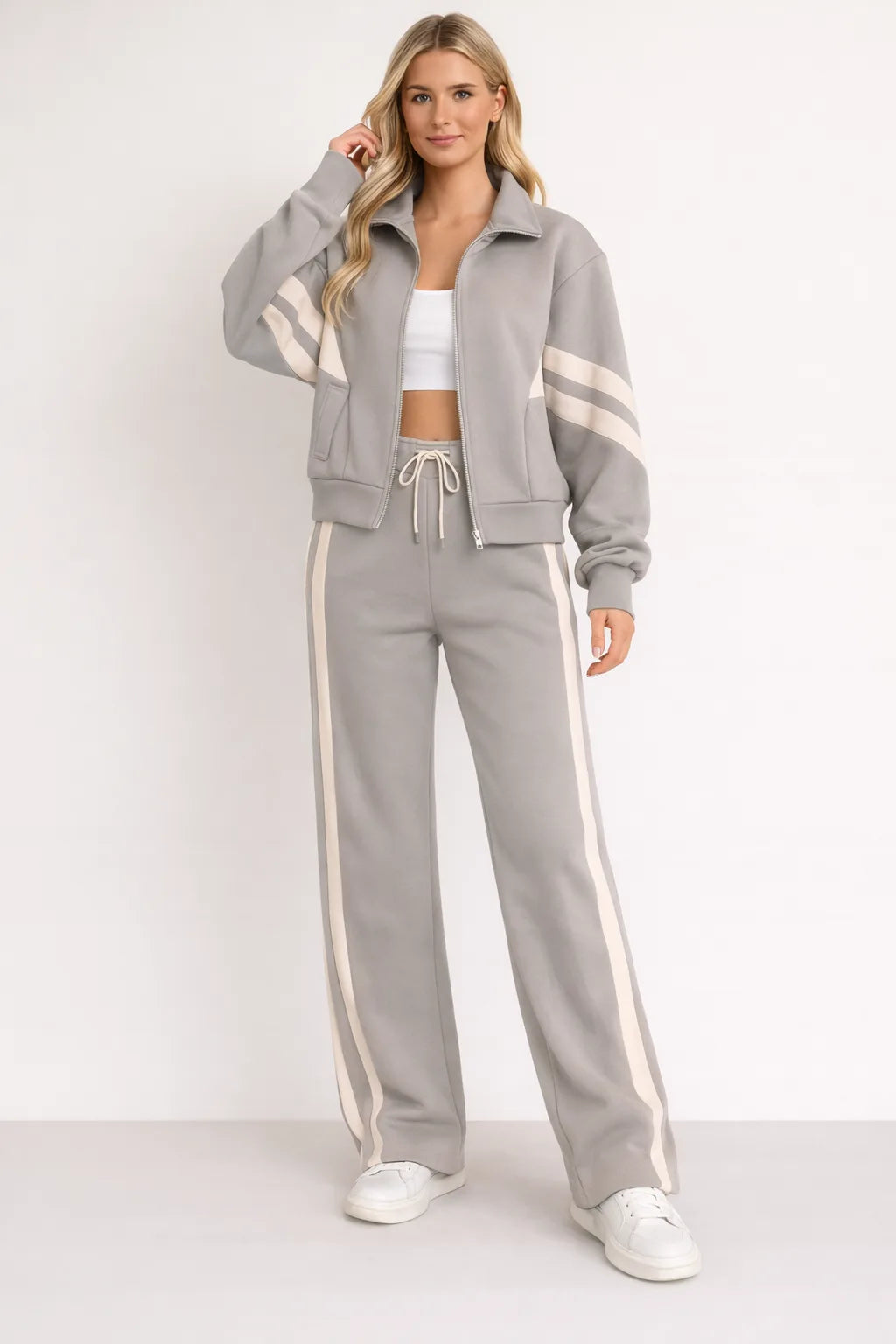 Grey zip-up tracksuit jacket with cream stripe detailing shown with matching grey wide-leg joggers and cream side stripes