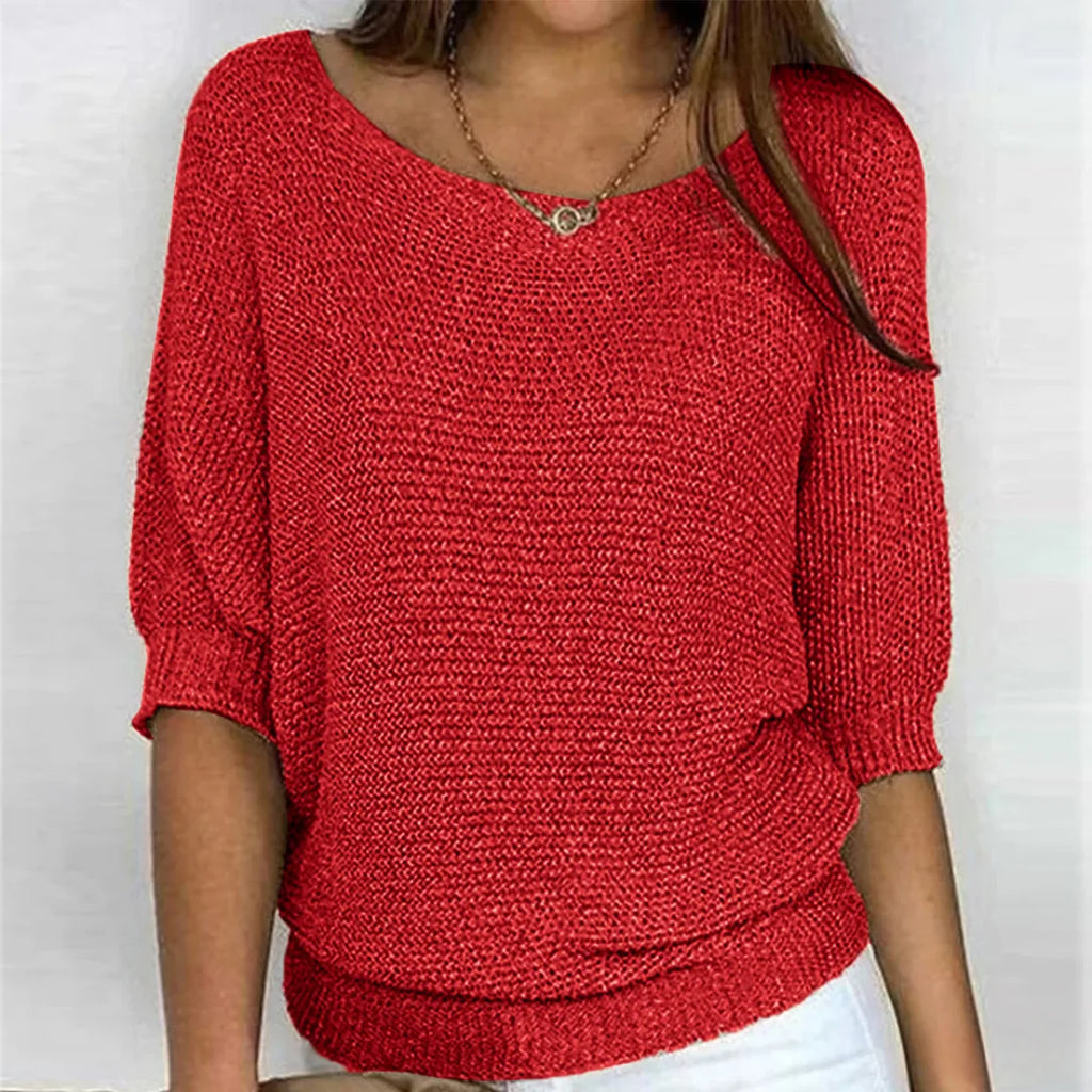 Red textured knit jumper worn with white trousers, showing ribbed cuffs and hem