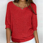 Red textured knit jumper worn with white trousers, showing ribbed cuffs and hem