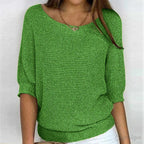 Green knitted jumper with dolman sleeves paired with white trousers