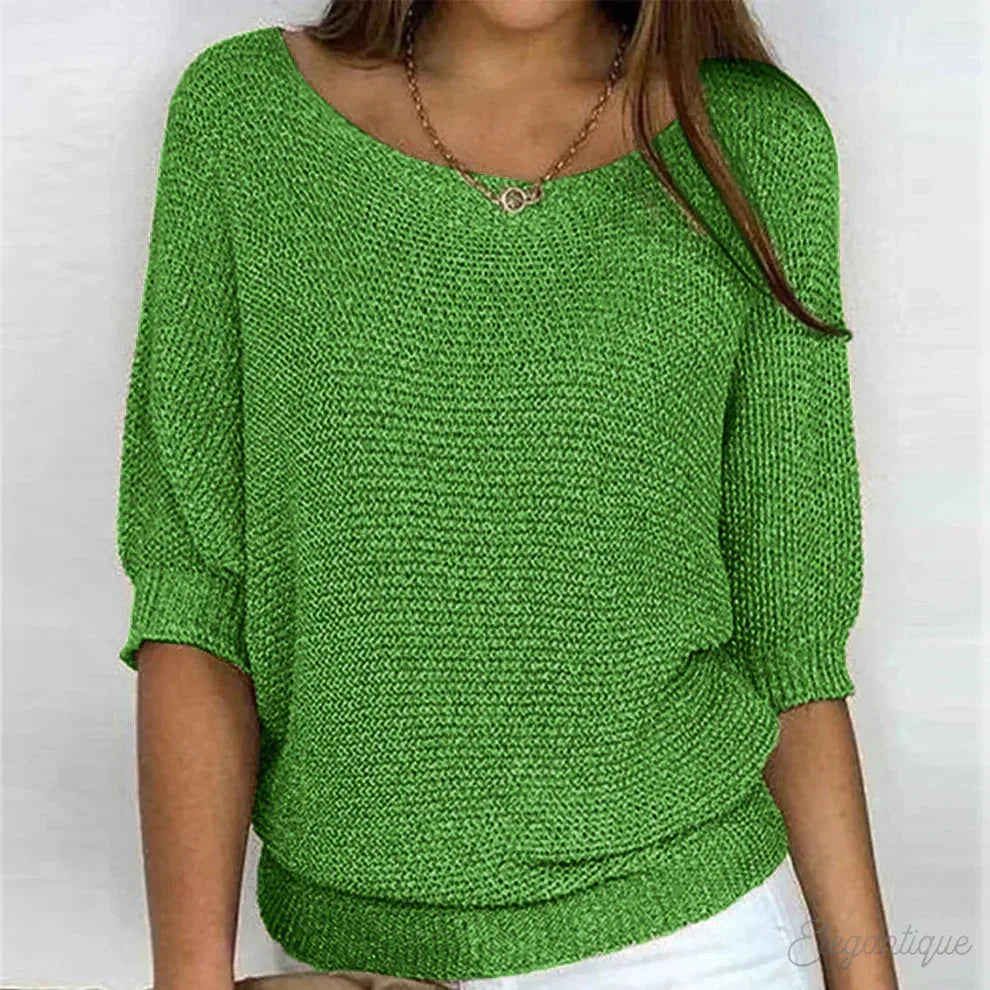 Green knitted jumper with dolman sleeves paired with white trousers