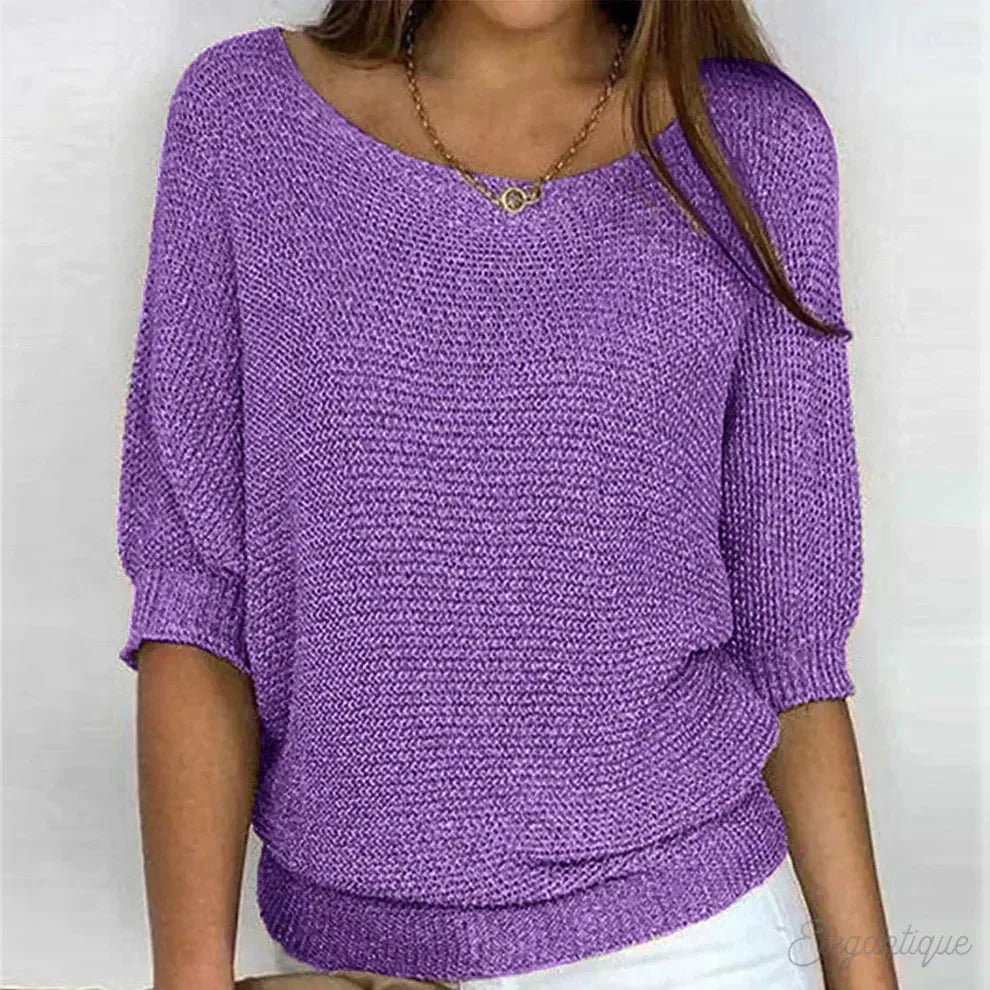 Purple knitted jumper close-up showing off-shoulder style neckline and knit pattern