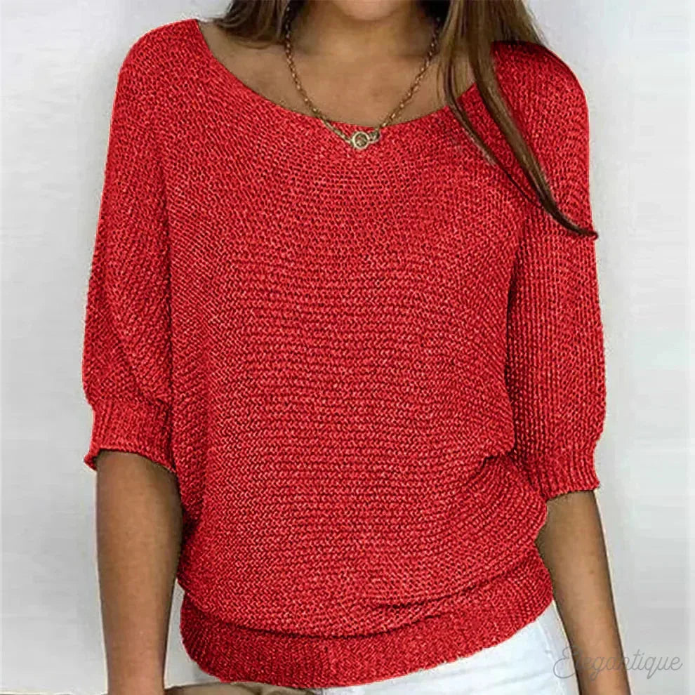 Front view of knitted jumper highlighting the fitted ribbed hem and loose batwing sleeves