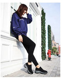 Rear angle of black slip-on trainers showing the ribbed ankle cuff and chunky tread sole