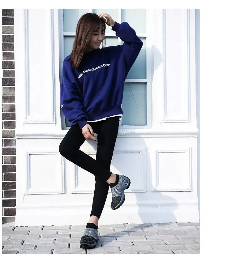 Close-up of the ribbed knit collar and air-cushion heel detail on a black sock-style trainer