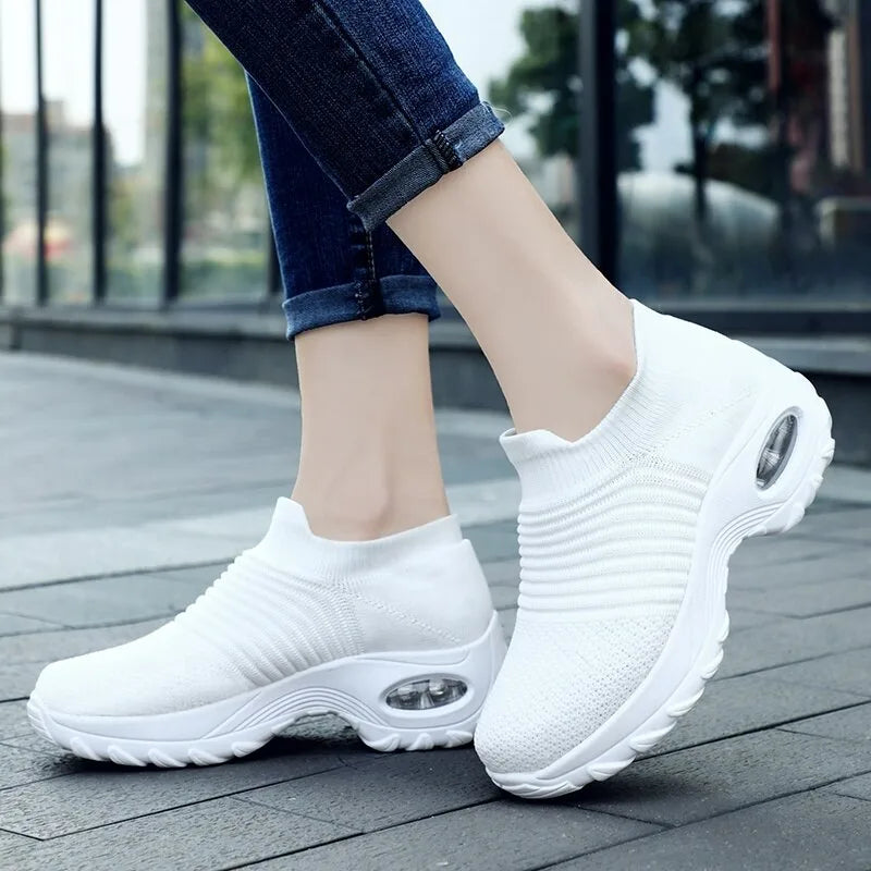 Black sock trainers with chunky white sole and air cushion detail, worn with dark skinny jeans