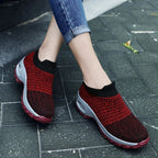 Purple and black knitted sock trainers with grey platform sole and visible air cushion in the heel